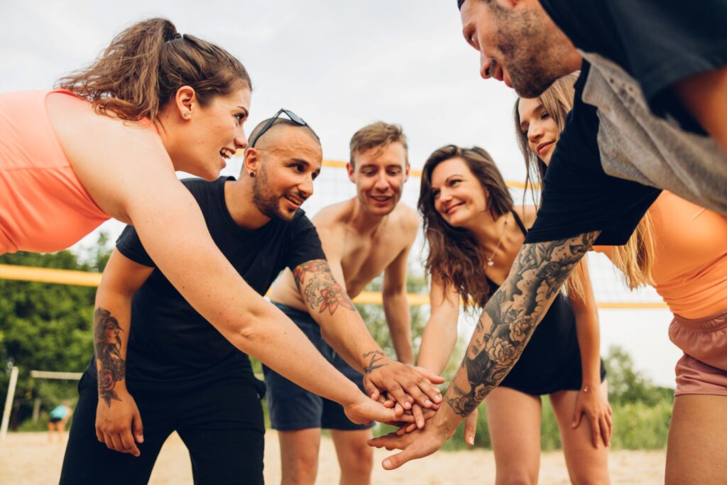 Group of men and women playing volleyball, using team sports as exercise for public speaking anxiety to build confidence and social communication skills.