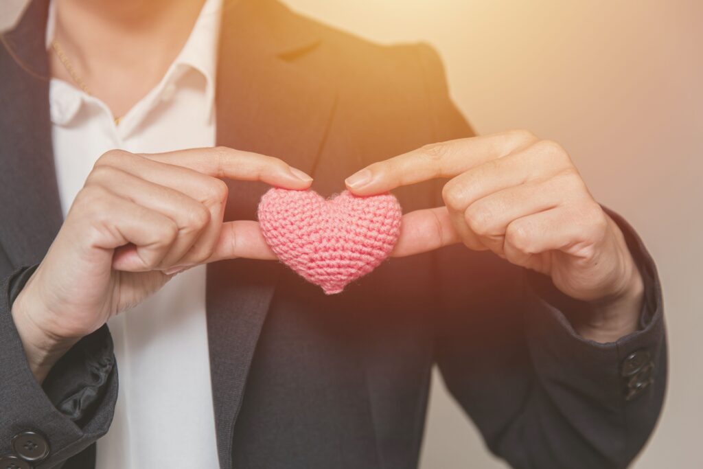 A person holding a heart symbol, representing the importance of care and empathy in how to make your audience feel connected.