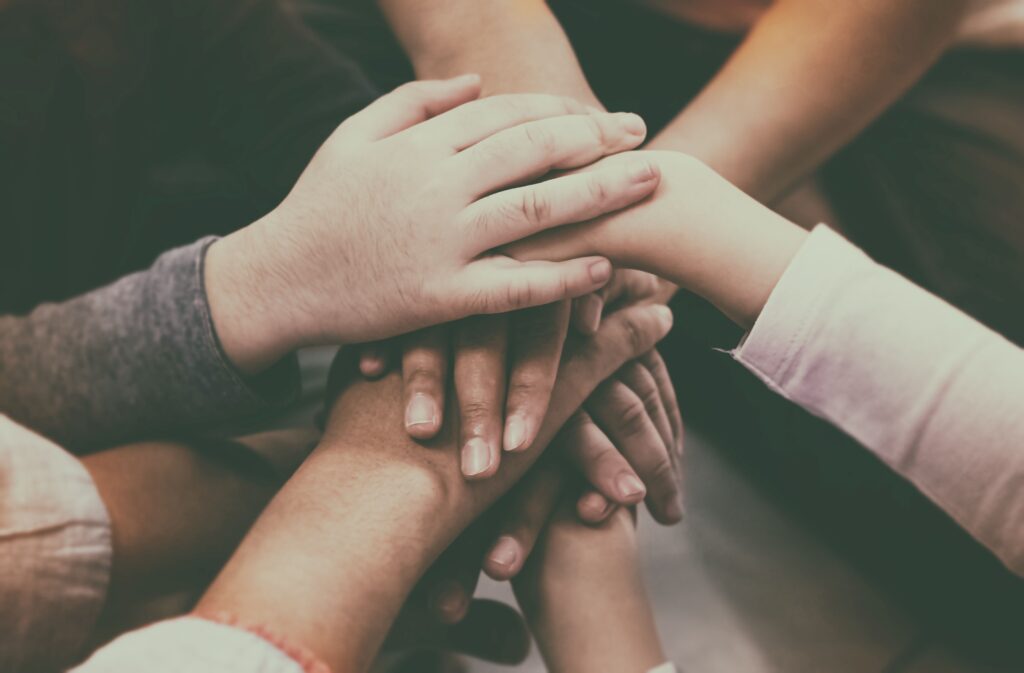 Hands connecting in a circle, symbolizing unity and illustrating how to make your audience feel connected through care and collaboration.