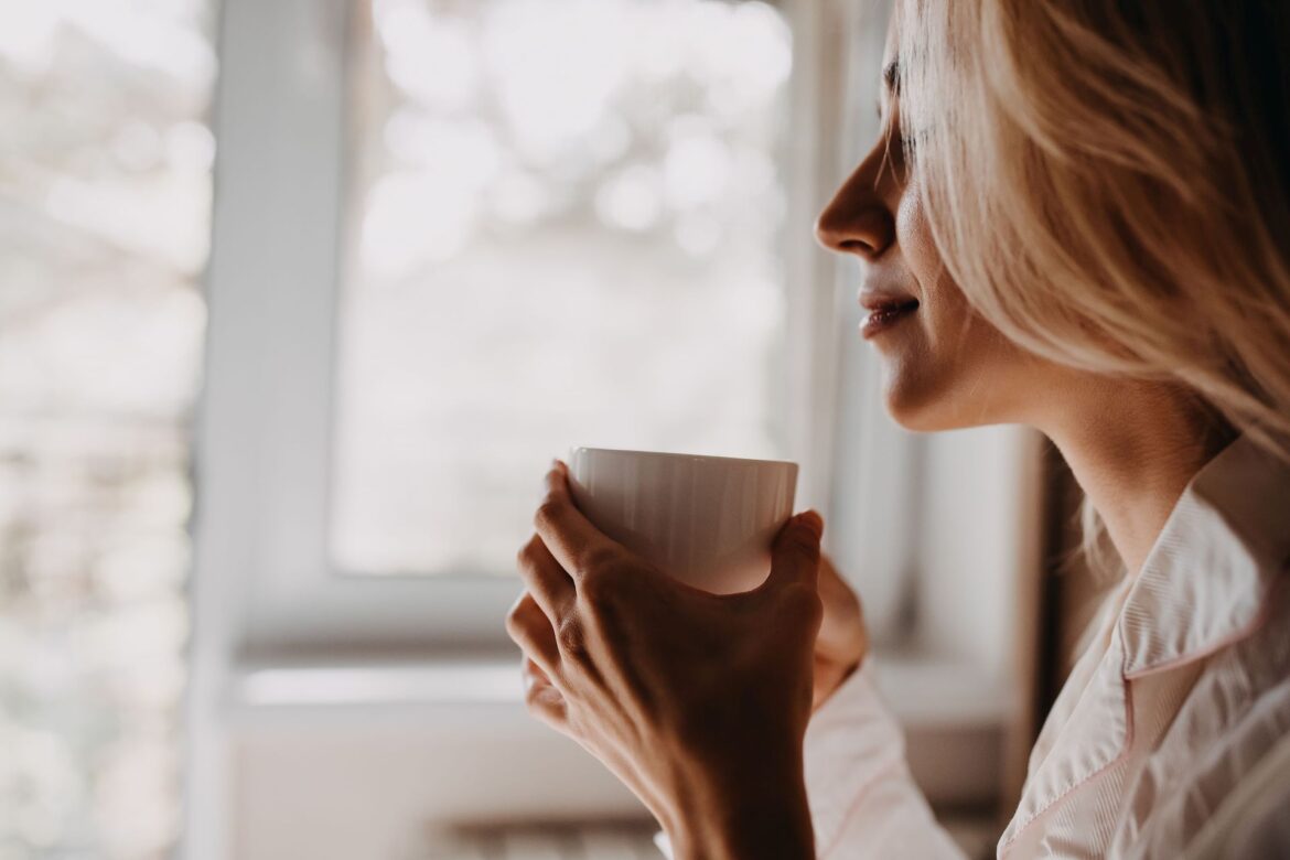 A woman with a coffee cup, fully present in the moment. Practicing mindfulness like this is a simple way to learn how to be more present everyday.