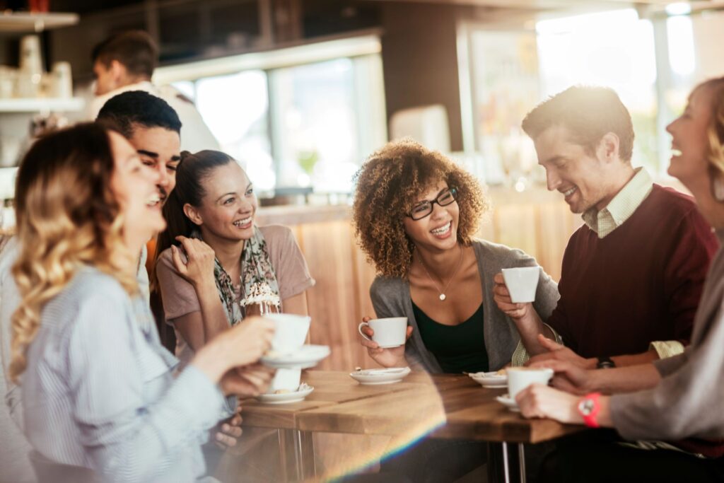 A group of friends smiling and enjoying time together, fully present in the moment. A reminder of how to be more present daily and build deeper connections.