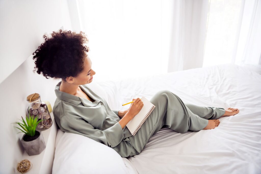 A woman writing in a notebook, practicing mindfulness through journaling. A simple habit to stay focused and learn how to be more present daily.