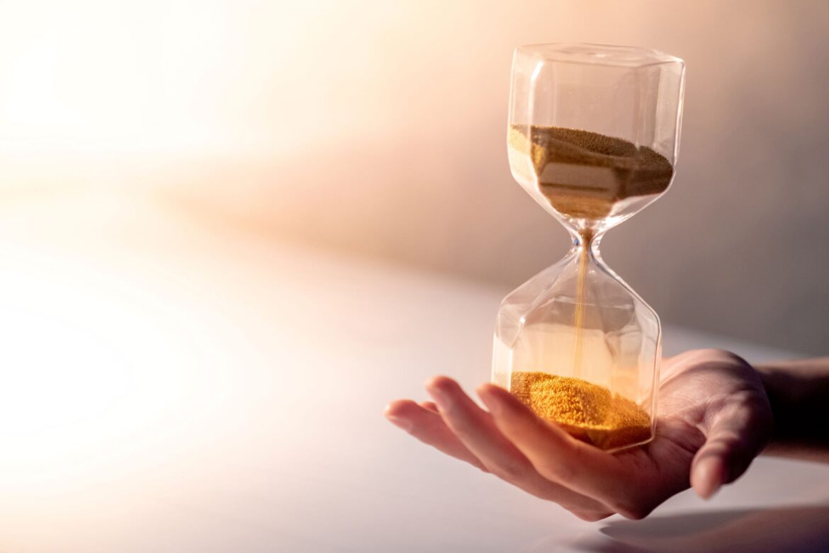 Why you need to pause – an hourglass with sand slowly running through, symbolizing the importance of slowing down, being present, and making intentional choices.