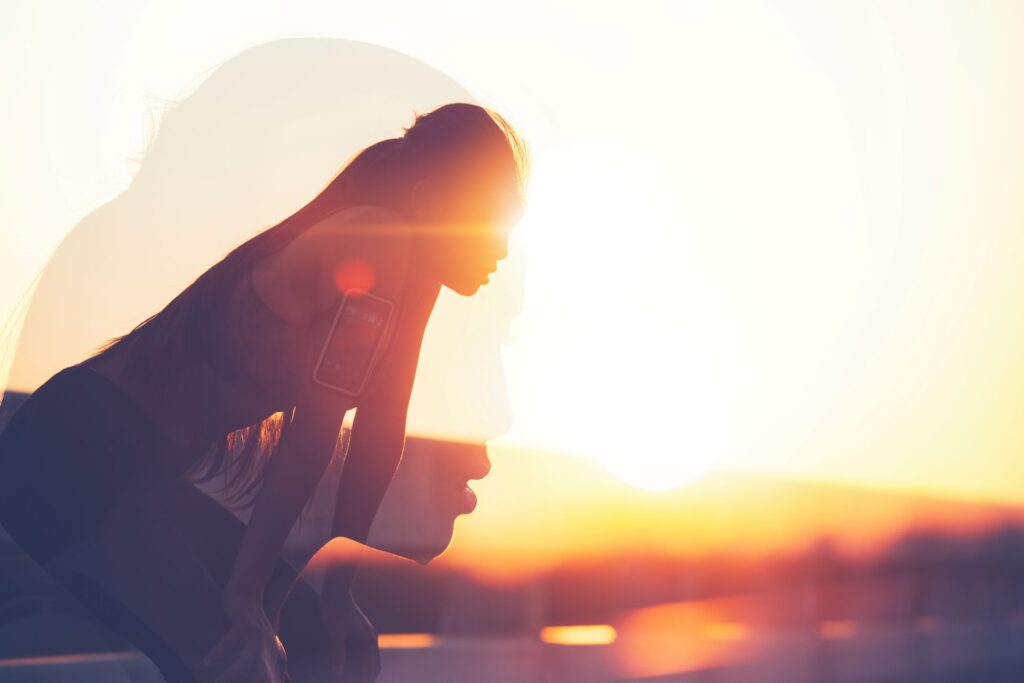 Woman pausing to catch her breath after a workout, symbolizing breath control techniques for overcoming fear of public speaking.