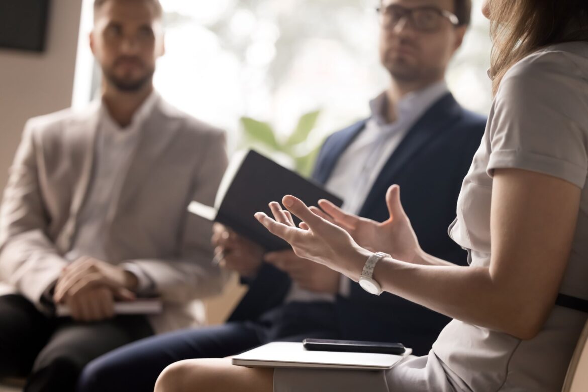 Businesswoman speaking confidently in a team meeting, using hand gestures to communicate ideas.